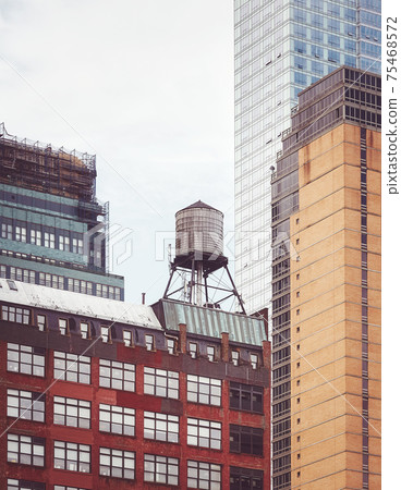 Old water tower, one of New York City symbols, among modern buildings, color toning applied, USA. Old water tower, one of New York City symbols, among modern buildings, color toning applied, USA. 75468572