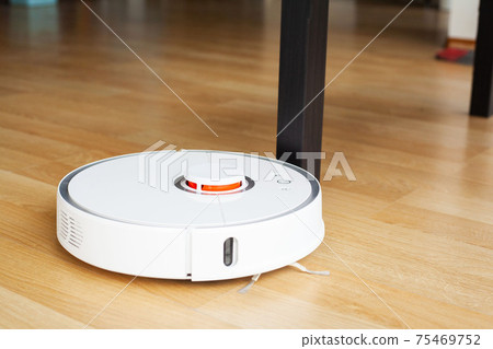 Robot vacuum cleaner performs automatic cleaning of the apartment at a certain time. Smart home. Robot vacuum cleaner performs automatic cleaning of the apartment at a certain time. Smart home. 75469752