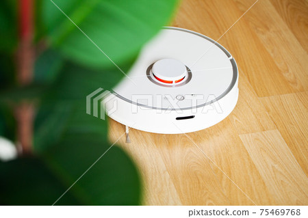 Robot vacuum cleaner performs automatic cleaning of the apartment at a certain time. Smart home. 75469768