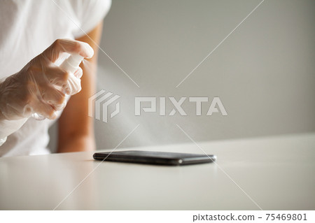 Close up woman disinfecting phone with antiseptic Close up woman disinfecting phone with antiseptic 75469801