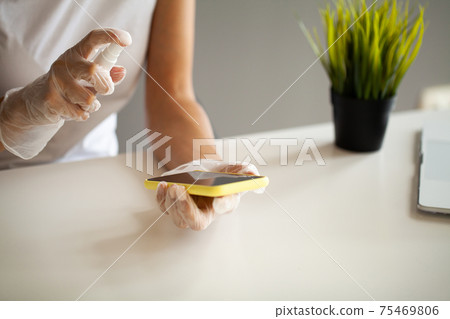 Close up woman disinfecting phone with antiseptic Close up woman disinfecting phone with antiseptic 75469806
