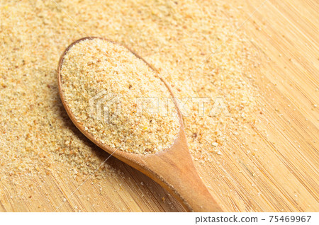 Fresh and tasty bread crumbs galeta flour in wooden spoon on bamboo cutting board 75469967