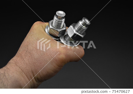 Galvanized steel metal dowel with metric bolt and hand, isolated on black background 75470627
