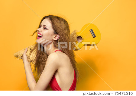 Cheerful woman in red ukulele t-shirt Exotic fruit yellow background lifestyle 75471510