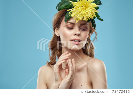 beautiful woman with yellow flower near face smiling cropped view portrait of bared shoulders 75472415