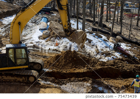 Excavator is digging a huge trench, ditch for drainage canal utility pipe pipeline installation 75473439