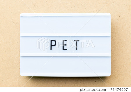 White lightbox with word PET (animal or abbreviation of polyethylene terephthalate) on wood background 75474907