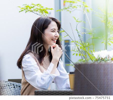 A woman who makes a tea at a cafe A woman who makes a tea at a cafe 75475731