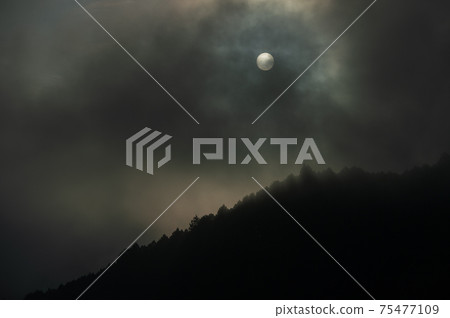 山脊上空有一團烏雲。太陽躲起來了，是暴風雨的跡象嗎？ 75477109
