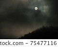 There is a dark cloud over the mountain ridge. The sun is hiding, a sign of stormy weather? 75477116