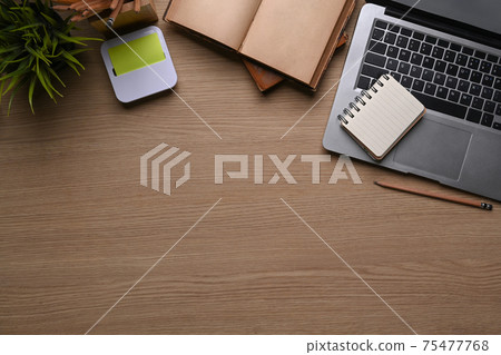 Above view of comfortable workplace with laptop computer, notebook, plant, sticky note and copy space. on wooden background. Above view of comfortable workplace with laptop computer, notebook, plant, sticky note and copy space. on wooden background. 75477768