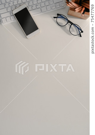 Mock up smart phone, wireless keyboard, eye glasses and copy space on white office desk. Mock up smart phone, wireless keyboard, eye glasses and copy space on white office desk. 75477769