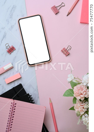 Above view of mock up smartphone and office supplies on pink and marble background. Above view of mock up smartphone and office supplies on pink and marble background. 75477770