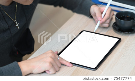 Cropped shot of man holding stylus pen pointing on screen of digital tablet. Cropped shot of man holding stylus pen pointing on screen of digital tablet. 75477774