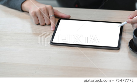 Close up view of man holding stylus pen pointing on digital tablet. Close up view of man holding stylus pen pointing on digital tablet. 75477775