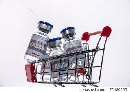 Glass vials for vaccine in shopping cart on white background. Group of vaccine bottles in basket. 75480365
