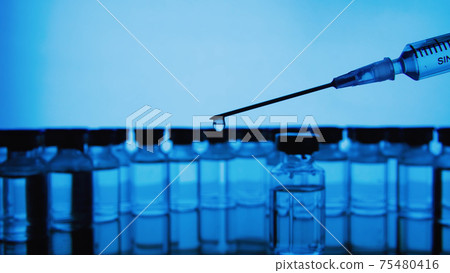 Vaccine bottles and syringe injection. Medicine in ampoules. Glass vials for liquid samples in laboratory. 75480416