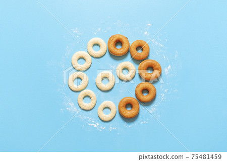Cooking doughnuts process. Homemade dough and deep-fried donuts, top view Cooking doughnuts process. Homemade dough and deep-fried donuts, top view 75481459