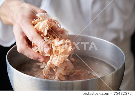 板前將乾魚放入鍋中 板前將乾魚放入鍋中 75482573