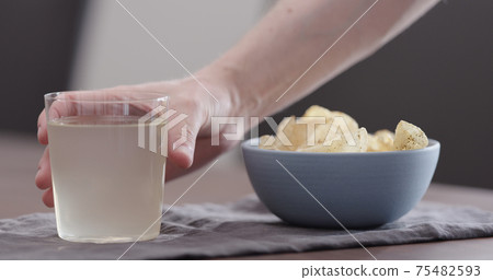 man take potato chips with ground pepper and salt and drink ginger beer 75482593