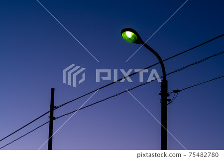 黃昏的藍色漸變天空和電線桿與路燈 75482780