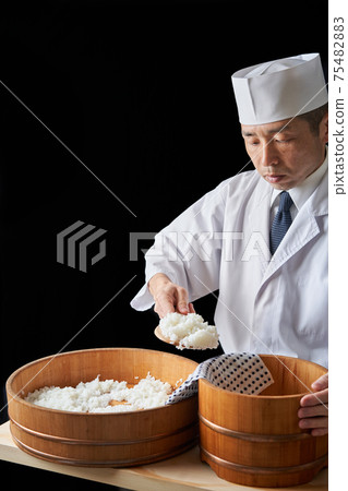 Itamae to transfer vinegared rice to a bowl 75482883