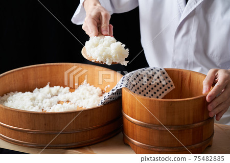 Itamae to transfer vinegared rice to a bowl 75482885