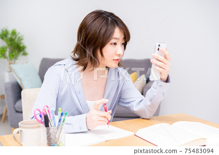 在客廳裡學習的年輕女子 在客廳裡學習的年輕女子 75483094