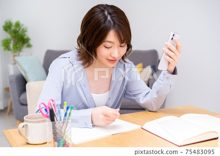 在客廳裡學習的年輕女子 在客廳裡學習的年輕女子 75483095