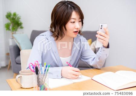 Young woman studying in the living room Young woman studying in the living room 75483096