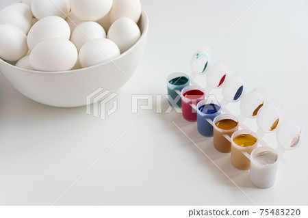 Bowl of eggs and paints on white background 75483220