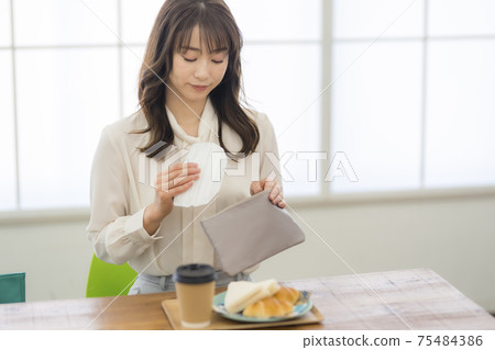 Woman having breakfast at a cafe_Corona 75484386