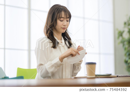 Woman having breakfast at a cafe_Corona 75484392