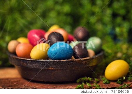 Chocolate Easter eggs with egg candies on a wooden table in the yard Chocolate Easter eggs with egg candies on a wooden table in the yard 75484666