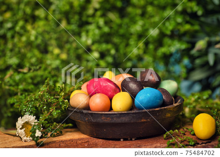 Chocolate Easter eggs with egg candies on a wooden table in the yard Chocolate Easter eggs with egg candies on a wooden table in the yard 75484702
