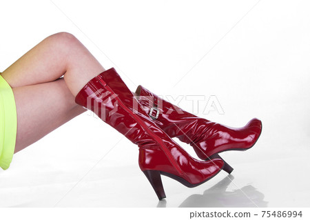 Beautiful legs in beautiful red patent leather boots. Isolated on white background Beautiful legs in beautiful red patent leather boots. Isolated on white background 75486994