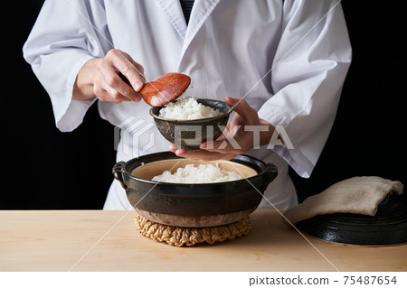 Itamae with rice cooked in a clay pot 75487654