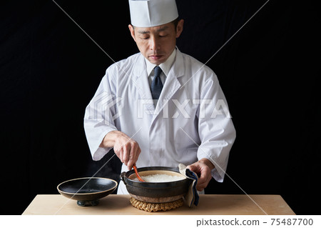 Itamae to loosen rice cooked in a clay pot 75487700