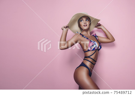 Charming blond girl in one-piece swimsuit and straw hat Charming blond girl in one-piece swimsuit and straw hat 75489712