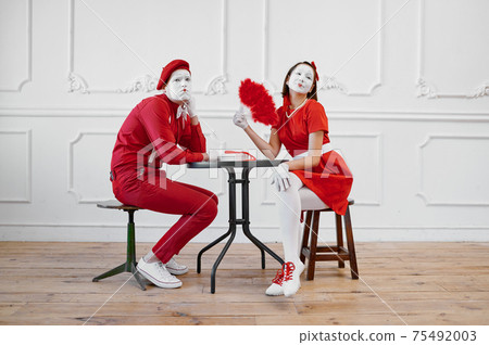 Mime artists in red costumes, scene at the table 75492003