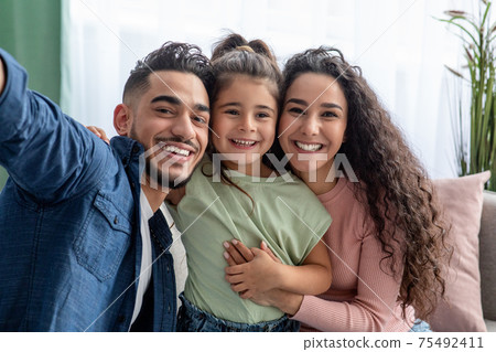 Family Selfie. Cheerful Arab Man Taking Photo With Wife And Little Daughter 75492411