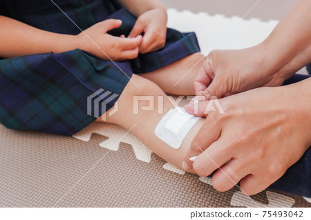 A nursery teacher who treats a child's injury 75493042