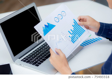 Hand of young business man looking document data graph and chart paper, marketing and investment. Hand of young business man looking document data graph and chart paper, marketing and investment. 75493318