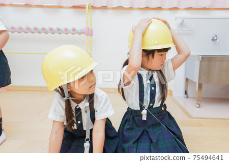 Children wearing helmets and evacuating Children wearing helmets and evacuating 75494641