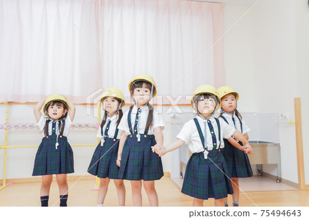 Children wearing helmets and evacuating 75494643