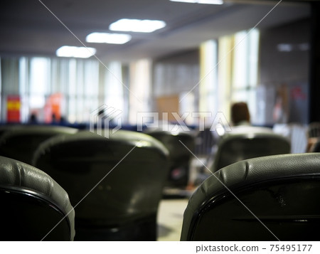 blur lonesome abandoned almost empty passenger's waiting room in front of gate in a previous tourist destination airport in COVID-19 pandemic era  75495177