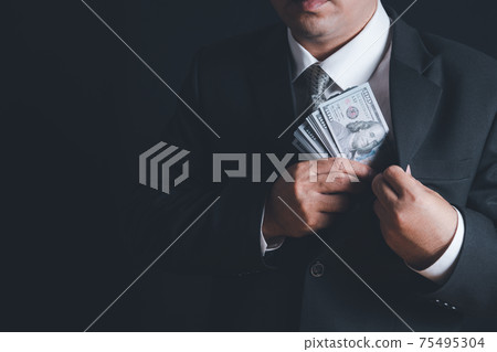 Man putting bribe money into pocket on black background, Man putting bribe money into pocket on black background, 75495304