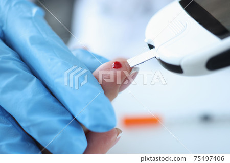 Blood is taken from patient for analysis with glucometer Blood is taken from patient for analysis with glucometer 75497406