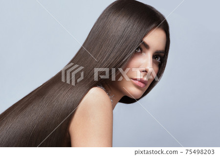 Beautiful brown-haired girl with a perfectly smooth hair, and classic make-up. Beauty face and hair. 75498203