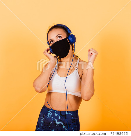 Close up portrait of beautiful young african american sports woman posing against yellow background 75498455
